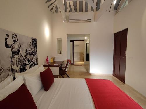 a bedroom with a white bed and a dining room at Mangala Heritage by LuxUnlock Private Villas in Tirukkannapuram