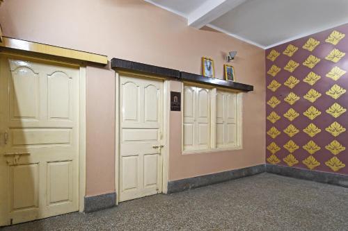 a room with two white doors and purple walls at Hotel O Arati House in Kolkata