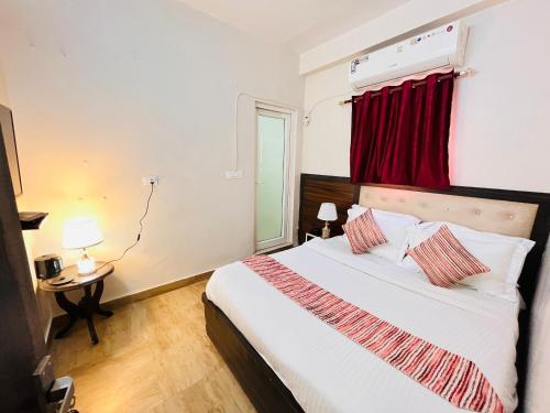 a bedroom with a bed with a red curtain at South Inn - Green Park South Delhi in New Delhi