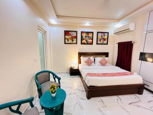 a bedroom with a bed and a chair and a table at South Inn - Green Park South Delhi in New Delhi