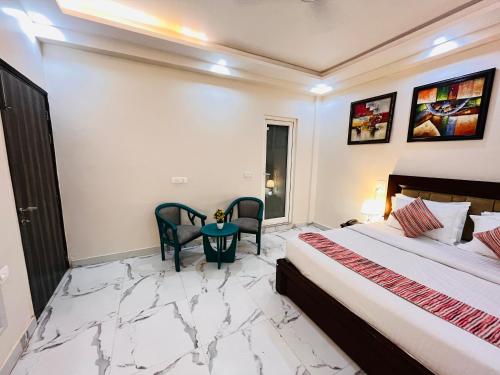 a bedroom with a bed and a table and chairs at South Inn - Green Park South Delhi in New Delhi