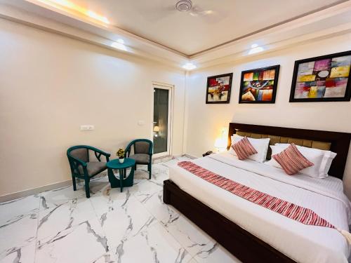 a bedroom with a bed and a table and chairs at South Inn - Green Park South Delhi in New Delhi
