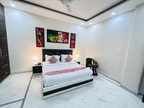 a bedroom with a large bed with two tables and two lamps at South Inn - Green Park South Delhi in New Delhi
