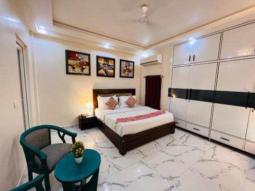 a bedroom with a bed and a chair at South Inn - Green Park South Delhi in New Delhi