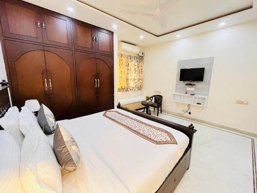 a bedroom with a large bed and a tv at South Inn - Green Park South Delhi in New Delhi
