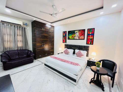 a bedroom with a king sized bed and a chair at South Inn - Green Park South Delhi in New Delhi