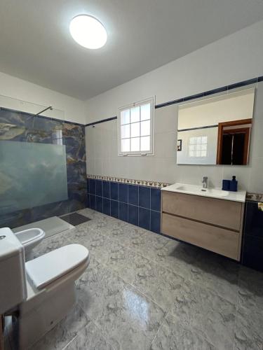 a bathroom with a toilet and a sink and a mirror at Casa Tortuga in Tarajalejo
