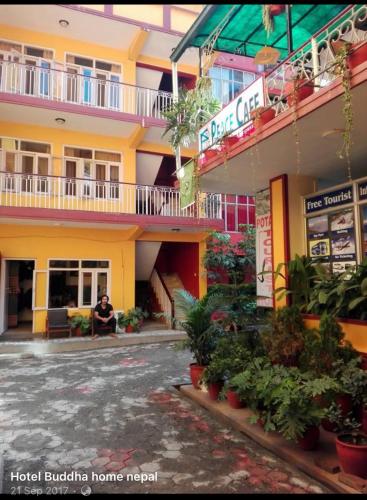 a man sits in front of a hotel building at Buddha Home Nepal in Thapathali