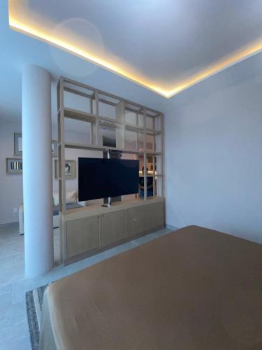 un salon avec une télévision à écran plat sur un mur dans l'établissement Nayfer Suites, à Playa del Carmen