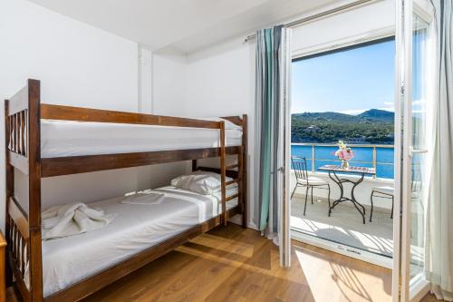 a bedroom with two bunk beds and a balcony at Hotel Timun in Gdinj