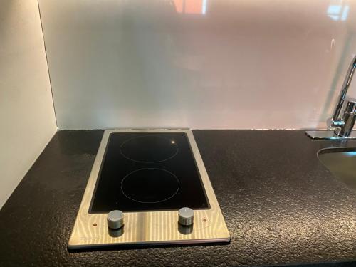 a black counter top with a stove and a sink at Nayfer Suites in Playa del Carmen