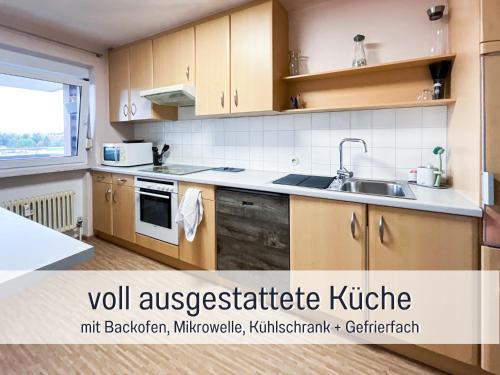 a kitchen with wooden cabinets and a sink at Casa Michaela Öhringen - wunderschöne Aussicht - Top für Familien und Geschäftsreisen, super ausgestattet in Öhringen