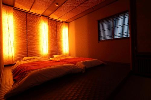 a bed in a room with lights on it at Hakone Onsen Ryokan Yaeikan in Hakone