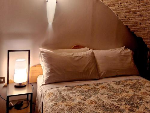 a bedroom with a bed with a pillow and a lamp at Case Brizi Assisi in Assisi