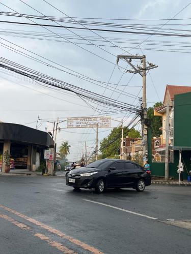 a black car is parked on a city street at The George Residence in Tarlac