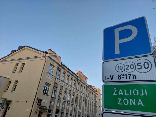 a parking sign in front of a building at Sweet Apartments in Šiauliai