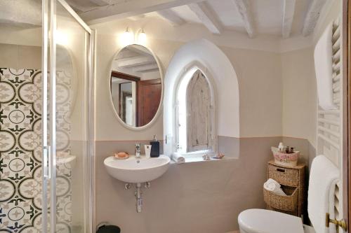 a bathroom with a sink and a toilet and a mirror at Civico 10 in Casale Marittimo