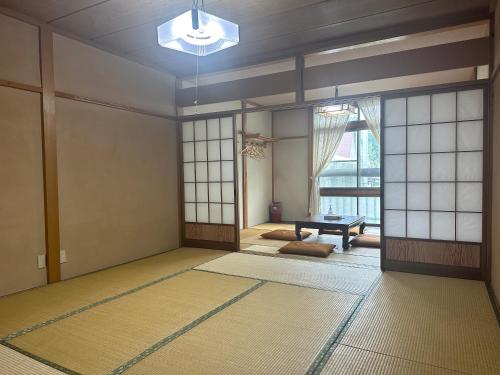 an empty room with a table and a window at 苗場ウッドインだいまる in Yuzawa