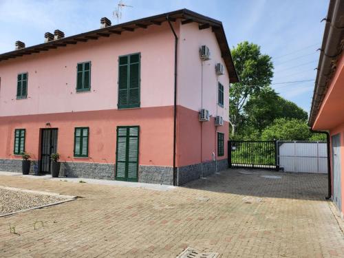 a pink house with a black gate at Il mulino foresteria in Parona