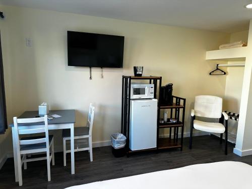 a room with a table and a refrigerator and a microwave at Dock Street Inn in Westport