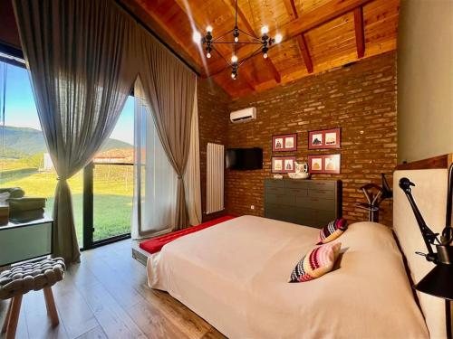 a bedroom with a large bed and a large window at Villa Chateau Artwine in Art'ana