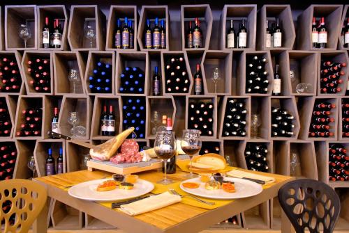 a table in a wine cellar with wine bottles at The Gate Hotel - Firenze Nord in Sesto Fiorentino
