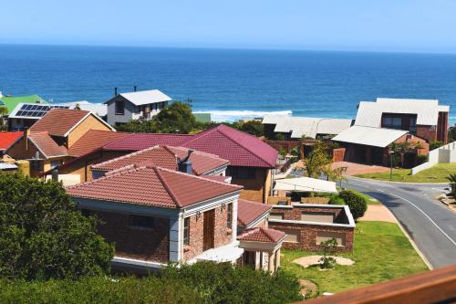 a row of houses with the ocean in the background at BergWood Inn in Groot Brak Rivier