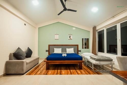 a bedroom with a bed and a couch at Commune18 Resort Chikmagalur in Chikmagalūr