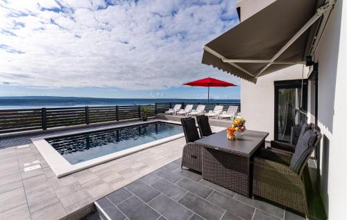 a patio with a table and chairs and a swimming pool at Stunning Home In Maslenica With Wifi in Maslenica