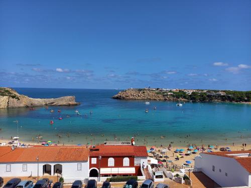 a beach with a bunch of people in the water at Solisla in Arenal d'en Castell