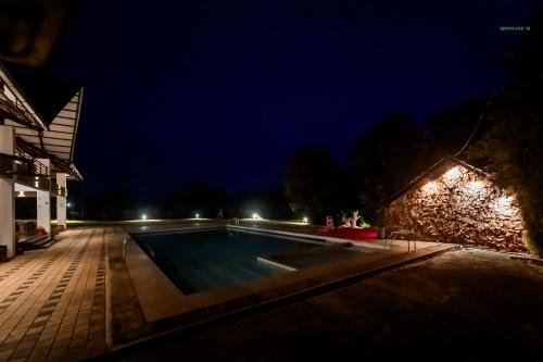 an empty swimming pool at night at Commune18 Resort Chikmagalur in Chikmagalūr