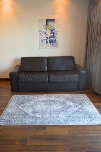 a black leather couch in a living room with a table at BergWood Inn in Groot Brak Rivier