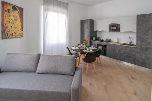 a living room with a couch and a table and a kitchen at VigevanoRent in Vigevano
