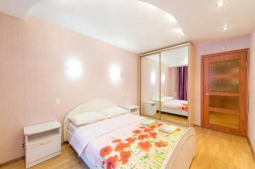 a bedroom with a bed and a large mirror at Five Stars Monakova in Chelyabinsk