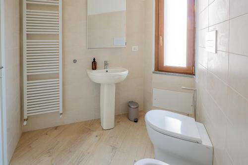 a white bathroom with a toilet and a sink at VigevanoRent in Vigevano