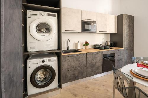 a kitchen with a washing machine and a washer and dryer at VigevanoRent in Vigevano