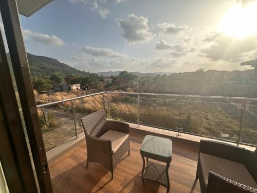 a balcony with chairs and a view of the mountains at Woods by Mizzle Exotica Premium Villas in Lonavala