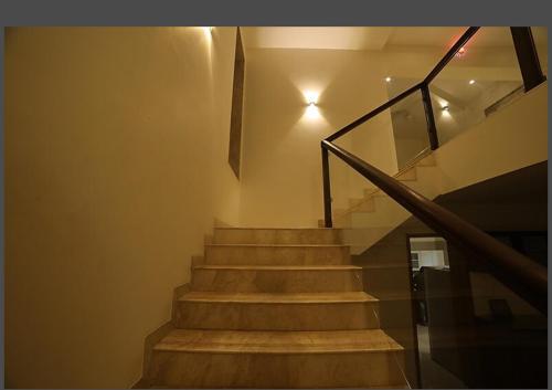 a staircase with wooden steps and a glass railing at Woods by Mizzle Exotica Premium Villas in Lonavala