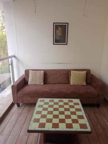 a living room with a couch and a chessboard at Woods by Mizzle Exotica Premium Villas in Lonavala
