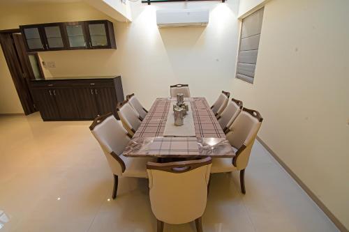 a dining room table with chairs and a table and a table and chairsktop at Woods by Mizzle Exotica Premium Villas in Lonavala
