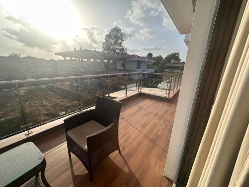a balcony with a table and chairs on a balcony at Woods by Mizzle Exotica Premium Villas in Lonavala