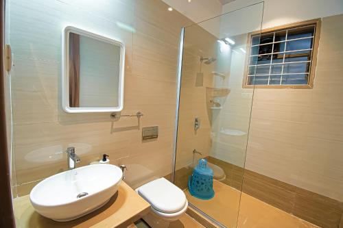 a bathroom with a sink and a glass shower at Woods by Mizzle Exotica Premium Villas in Lonavala