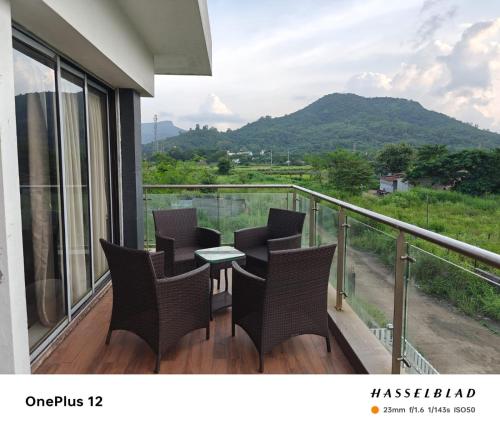 a balcony with chairs and a table with a view at Woods by Mizzle Exotica Premium Villas in Lonavala