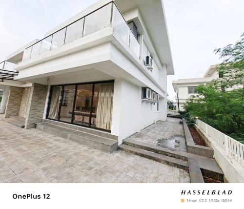 a white building with a balcony on the side of it at Woods by Mizzle Exotica Premium Villas in Lonavala