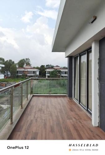 a balcony with a view of a house at Woods by Mizzle Exotica Premium Villas in Lonavala