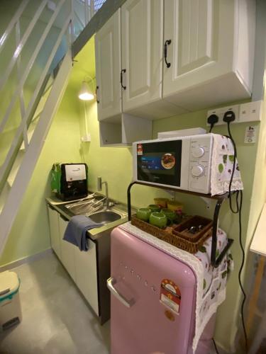 a kitchen with a pink refrigerator with a microwave on it at Seri Idaman Room and Studio - MusIim Only in Kampong Gaung