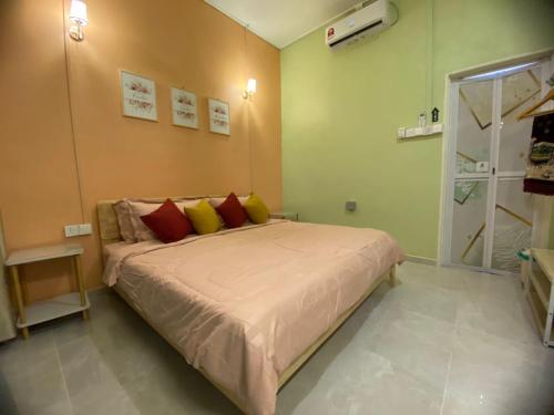 a bedroom with a bed with yellow and red pillows at Seri Idaman Room and Studio - MusIim Only in Kampong Gaung