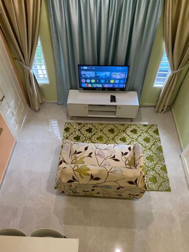 a living room with a couch and a flat screen tv at Seri Idaman Room and Studio - MusIim Only in Kampong Gaung
