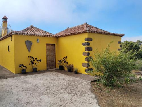 a yellow house with plants in front of it at Casa Rural de Abuelo in Garafía