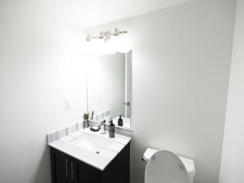a bathroom with a sink and a toilet and a mirror at Executive 3 Bedroom Town House in Mississauga